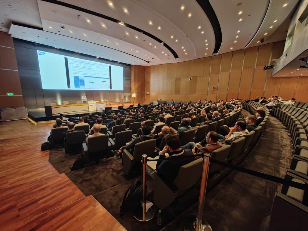 Auditorium at the SAP Integration Modernization Summit with around 100 partners watching a presentation on a large screen